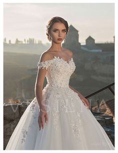 a woman in a white wedding dress posing for the camera with her hand on her hip