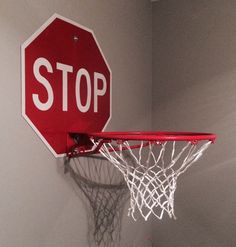 a red stop sign mounted to the side of a basketball hoop