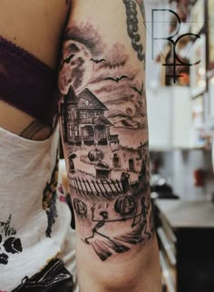 a woman's arm with a house and clouds tattoo on the left side of her body