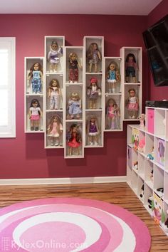 a living room filled with lots of dolls on shelves next to a pink rug in front of a window