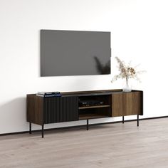 an entertainment center with a large flat screen tv mounted on the wall, in front of a white wall