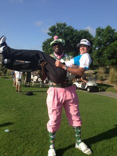 a man in pink pants and white shirt standing next to another person wearing green shoes