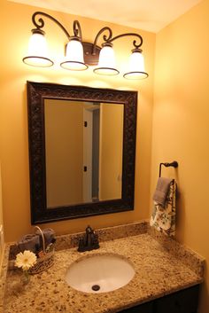 a bathroom with a sink, mirror and lights