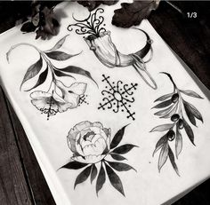 some flowers and leaves are drawn on a piece of paper with black marker markers in it