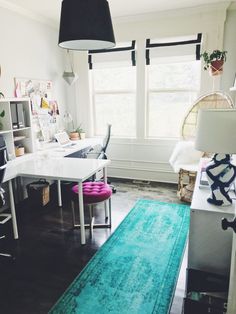 a room with a desk, chair and rug in it