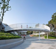 two people are walking up and down the stairs in front of a white circular building