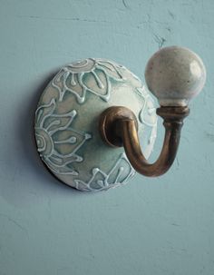 a light that is on the wall next to a blue painted wall with a white and gold handle