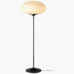 a black floor lamp with a white light on the top and bottom part of it