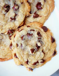 four chocolate chip cookies on a white plate