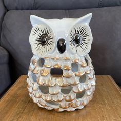 an owl figurine sitting on top of a wooden table next to a couch