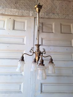 an old chandelier hanging from the ceiling in front of a white garage door