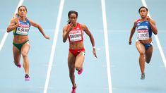 three female athletes running on a track