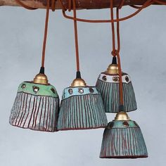 three blue and green lamps hanging from a ceiling