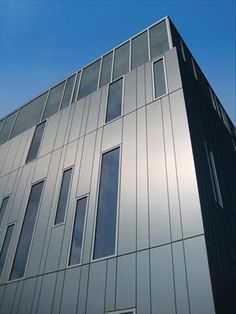 a tall building with many windows on it's side and a blue sky in the background