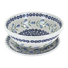 three bowls with blue flowers and leaves on the bottom, one bowl has two plates underneath it