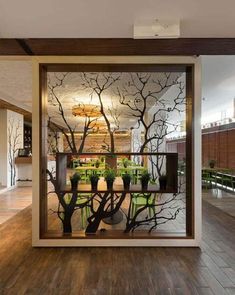 an open glass door with trees and plants in the center, on top of a wooden floor