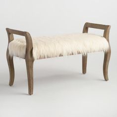 a wooden bench with white fur on the seat and back rests against a plain background