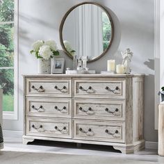 a white dresser and mirror in a room