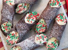 some type of pastry with sprinkles on it sitting on a plate next to a red and white striped napkin