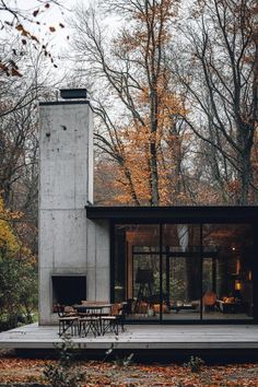 a concrete house surrounded by trees in the fall