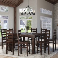 a dining room table and chairs in front of a fireplace with windows on both sides