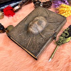 an open book sitting on top of a pink fur covered floor next to other items