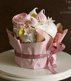 a pink cupcake with white frosting and flowers in a pink paper wrapper