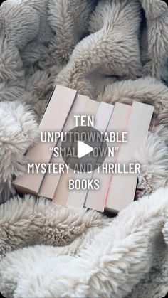 a pile of books sitting on top of a bed covered in white fluffy blankets and text that reads ten unplittownable small down mystery and thriller books