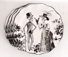 a black and white plate with two people dressed up in fancy clothing, one wearing a top hat