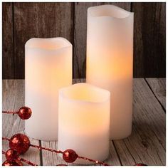 three lit candles on a wooden table