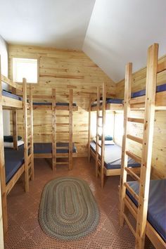 there are bunk beds in the room with no mattresses on them, and one has a rug on the floor