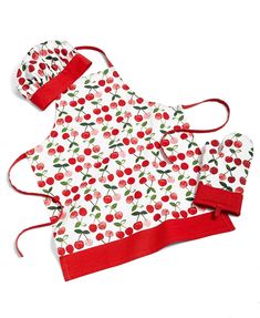 an apron and hat with cherries on it are sitting next to each other in front of a white background