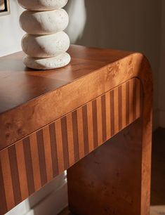 a stack of white rocks sitting on top of a wooden table next to a mirror