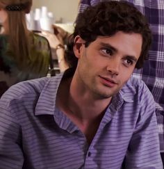 a man with curly hair is sitting down