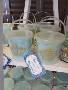 blue candles with gold crowns on them are for sale at a birthday party or baby shower