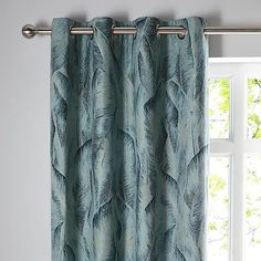 a curtain with blue feathers on it in front of a window