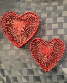 two red heart shaped baskets sitting on top of a table