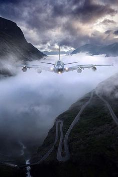 an airplane is flying low over the clouds and mountains in the night sky with it's landing gear down