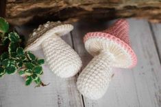 two knitted mushrooms sitting next to a plant