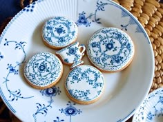 blue and white decorated cookies on a plate with wicker basket in the back ground