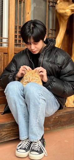 a person sitting on a bench with a cat