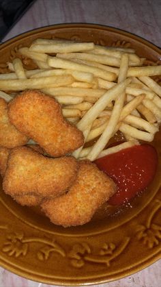 fried food on a plate with french fries and ketchup