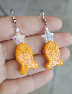 a pair of yellow earrings with white stars on them