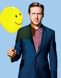 a man in a suit holding a balloon with a smiley face drawn on the side