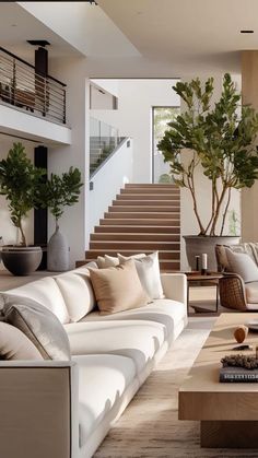 a living room filled with lots of furniture and a staircase leading up to the second floor