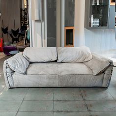 a couch that is sitting on the floor in front of a wall with glass doors