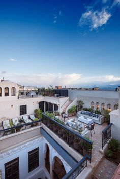 an outdoor hot tub on the roof of a building with patio furniture and potted plants