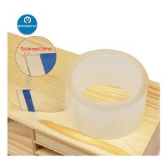 clear plastic tape on wooden table with blue and white stripe around the edge in front of it