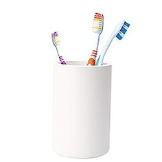 three toothbrushes in a cup on a white background