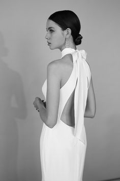 a woman in a white dress with a bow on her back